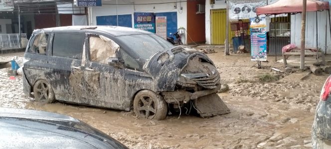 
					Salah satu mobil mewah milik warga Masamba yang rusak parah diterjang banjir bandang