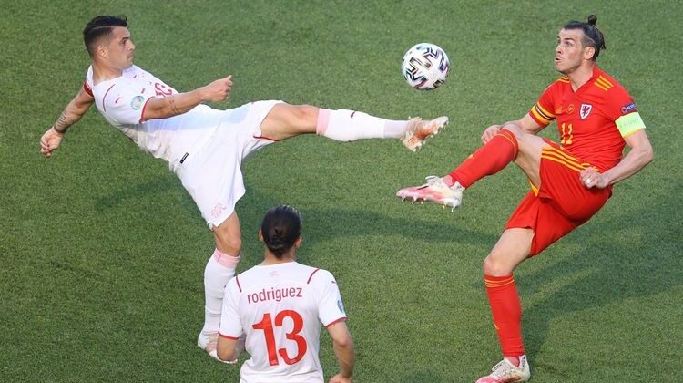 Bale berebut bola dengan pemain Swiss. Gambar (kompas.com)
