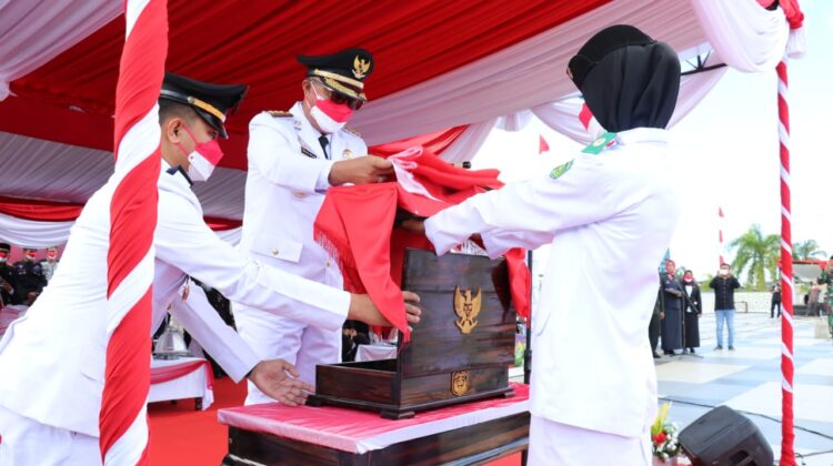 Bupati Luwu Timur ketika menyerahkan bendera untuk dikibarkan